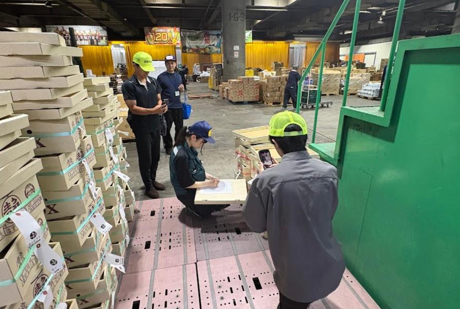 北部市場の青果売り場に積まれた段ボールとスタッフの様子